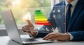 Man in suit interacting with energy efficiency interface on laptop showing house rating chart Royalty Free Stock Photo
