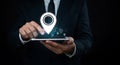 A man in a suit interacts with a digital tablet, with a large glowing location pin hoverin Royalty Free Stock Photo