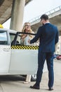 man in suit opening car door to beautiful smiling woman sitting Royalty Free Stock Photo