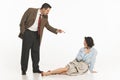 Man in suit pointing at seated woman on the floor, suggesting confrontation, dispute. Woman expressing shocked Royalty Free Stock Photo