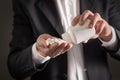 Man in a suit pouring spilling pills to hand. Royalty Free Stock Photo