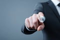 Man in suit pressing a translucent button with index finger, demonstrating technology, activation, or selection against neutral Royalty Free Stock Photo