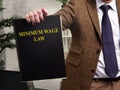 Man in a suit shows a book minimum wage law.