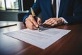 A man in a suit signing a legal document with a pen Royalty Free Stock Photo