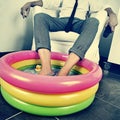 Man in suit soaking his feet in an inflatable water pool, with a