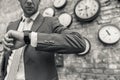 Man in suit standing near wall with clocks Royalty Free Stock Photo