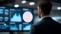 A man in a suit stands facing a large screen displaying various data visualizations, including bar graphs Royalty Free Stock Photo