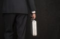 A man in a suit with a suitcase handcuffed on a black background, close-up, selective focus, dark tonality. Concept: secure delive