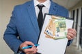 man in suit with a tablet tie in his hands and money stands in the hallway of the office. Royalty Free Stock Photo