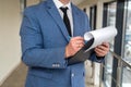 man in suit with a tablet tie in his hands and money stands in the hallway of the office. Royalty Free Stock Photo