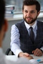 Man in suit and tie give hand as hello in office