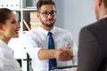 Man in suit and tie give hand as hello in office