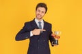 A man in a suit with a tie Handsome looking face with beard In the business man look Holding a trophy and pointing to the trophy Royalty Free Stock Photo