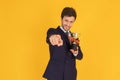 A man in a suit with a tie Handsome looking face with beard In the business man look Holding a trophy and pointing at you In the Royalty Free Stock Photo