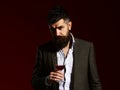 Man in suit toasting with sparkling glass of red wine