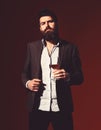 Man in suit toasting with sparkling glass of red wine