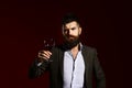 Man in suit toasting with sparkling glass of red wine