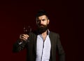 Man in suit toasting with sparkling glass of red wine