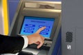 Man in suit touching display screen at ATM terminal