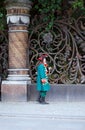 A man in a suit of Tsar Peter I is talking on a mobile phone, standing at the fence of the Church of the Savior on Spilled Blood. Royalty Free Stock Photo