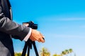 Man in a suit using a compact photo camera on a tripod to take a self-portrait to use as a profile in his business and social Royalty Free Stock Photo