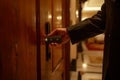 Man in a suit using a key card to access a secured door in a hotel corridor Royalty Free Stock Photo