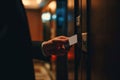 Man in a suit using a key card to access a secured door in a hotel corridor Royalty Free Stock Photo