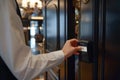 Man in a suit using a key card to access a secured door in a hotel corridor Royalty Free Stock Photo