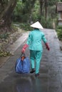 A man in a suit and in a Vietnamese traditional straw hat