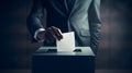 Man in a suit voting, putting paper in a ballot box, concept of politics and elections Royalty Free Stock Photo