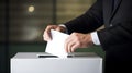 Man in a suit voting, putting paper in a ballot box, concept of politics and elections. Royalty Free Stock Photo