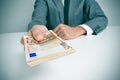Man in suit with a wad of euro bills Royalty Free Stock Photo