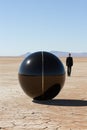 A man in a suit walking past a large black ball. Generative AI image.