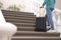 Man with suitcase going up stairs in hotel, closeup Royalty Free Stock Photo