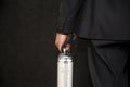 A man with a suitcase in handcuffs on a black background. Concept: secure delivery of money and documents, business courier, class