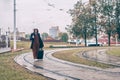 Man with a suitcase is walking along the road. guy holds an umbrella in the rain Royalty Free Stock Photo