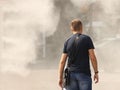 A man in summer clothes goes through the frame of a refreshing street shower. Use fine water dust during the hot season to refresh