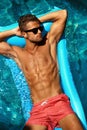Man Summer Fashion. Male Model Tanning By Pool. Skin Tan Royalty Free Stock Photo