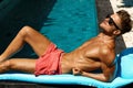 Man Summer Fashion. Male Model Tanning By Pool. Skin Tan Royalty Free Stock Photo