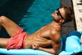 Man Summer Fashion. Male Model Tanning By Pool. Skin Tan Royalty Free Stock Photo