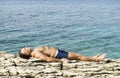 Man sunbathing on rocks Royalty Free Stock Photo