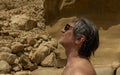 a man sunbathing in the sun against the background of yellow rocks, Greece, Crete, Matala Royalty Free Stock Photo