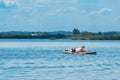man sunbathing on supboard in the middle of the lake