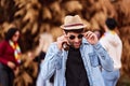 Man with sunglasses and hat holding a beer bottle while partying outdoors. Royalty Free Stock Photo