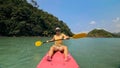 Man with sunglasses and hat rows pink plastic canoe along sea ag Royalty Free Stock Photo