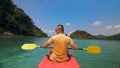 Man with sunglasses and hat rows pink plastic canoe along sea ag Royalty Free Stock Photo