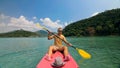 Man with sunglasses and hat rows pink plastic canoe along sea ag Royalty Free Stock Photo