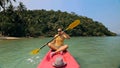 Man with sunglasses and hat rows pink plastic canoe along sea ag Royalty Free Stock Photo