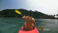 Man with sunglasses and hat rows pink plastic canoe along sea ag Royalty Free Stock Photo