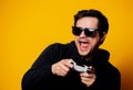 Man sunglasses keen plays with a joystick Royalty Free Stock Photo